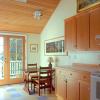 Recessed porch was absorbed into renovated kitchen, allowing enough room for a breakfast table.  Flat ceiling was removed.  New French doors open to a deck, and skylight helps balance the light.  Woodwork is Douglas fir with a natural finish.