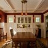 Dining room had lost most of its original features except  built-in buffet.  Windows on each side may have rested on a plate rail, so we added one with wainscoting below. A drywall ceiling was removed to uncover box beams.  Door and window cornices and arch in bay window were also added.