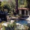 This view of lower garden shows naturalistic swimming pool.  To the right of French doors is a single door into bath  for its use as a cabana. 