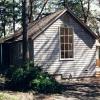 In a wooded area on the other side of camp we built this new cottage for Headmistress of Girls Camp.  Tall window faces south to catch a few rays.  Covered entry is to the left.  